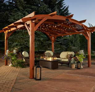 Handsome wooden pergola surrounds a comfortable arrangement of furniture outdoors