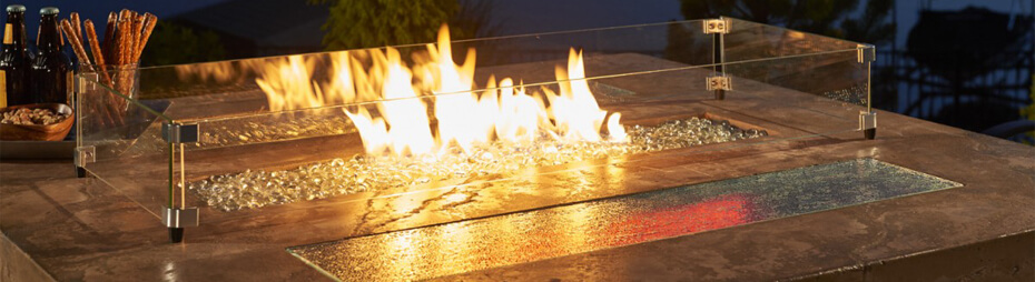 Close-up shot of bar-height gas fire pit table glass enclosure and flames