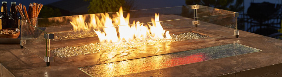 Close-up shot of bar-height gas fire pit table glass enclosure and flames Close-up shot of bar-height gas fire pit table glass enclosure and flames