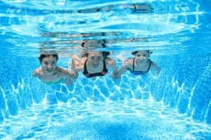 Mother and children swimming under water