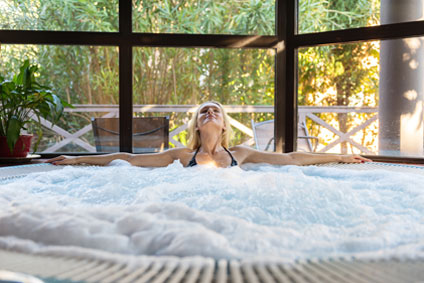 woman soaking in a luxurious, bubbly hot tub