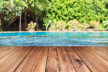 above ground pool with a deck in a beautifully landscaped backyard