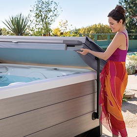 Person Lifting The Cover Off Of A Hot Tub