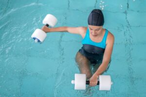 Swimmer in pool holding onto weights